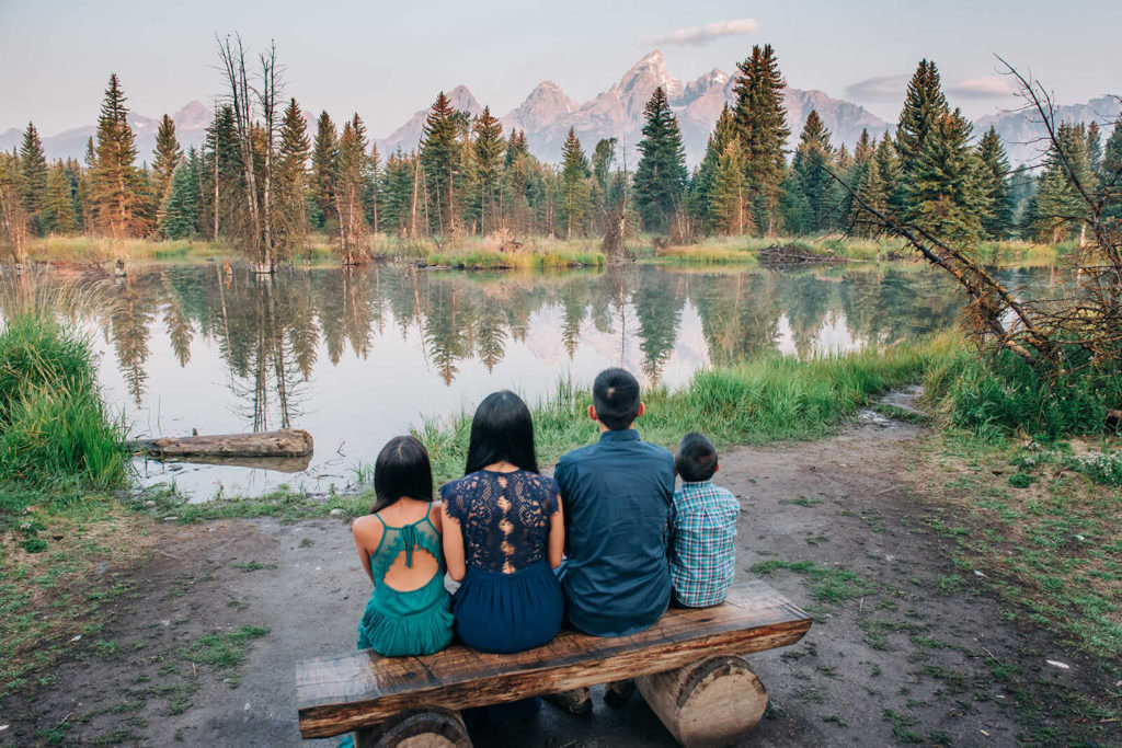 Family sitting on bench in front of water